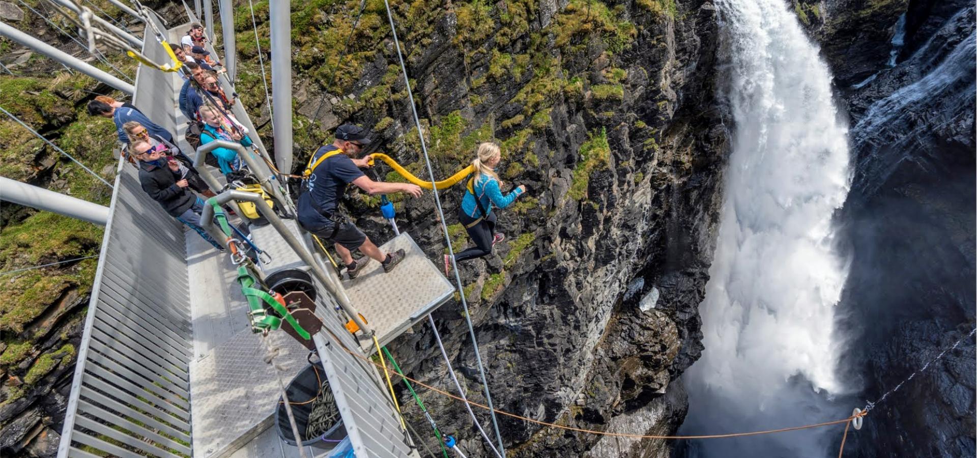 En person hopper fra gorsabrua i kåfjord om sommeren