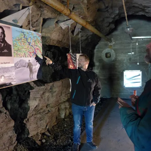 En guide forteller om utstillingen til en besøkende, de er inne i en bunkers