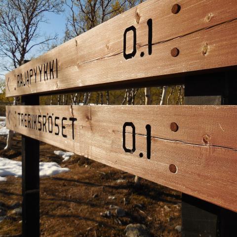 Wooden sign with 0.1 distance to Treriksrøysa