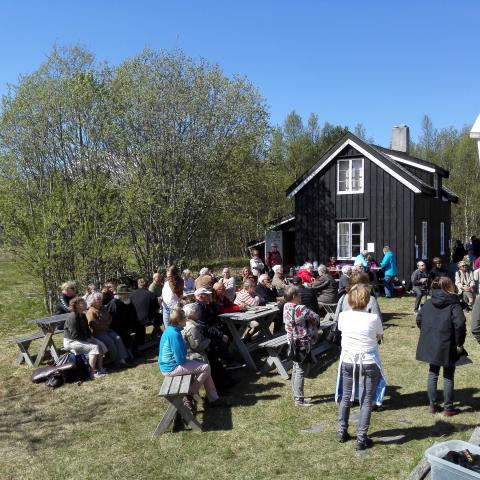 People enjoying a sunny day outside the Kven farm at Tørfoss