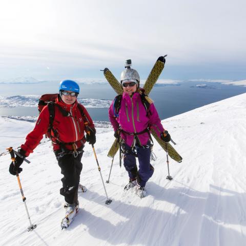 Two skiers on top of Russelvtinden, Lyngen Alps. With a fjord view