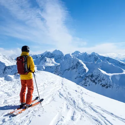 Skigåer som nyter utsikten fra toppen på en solskinnsdag